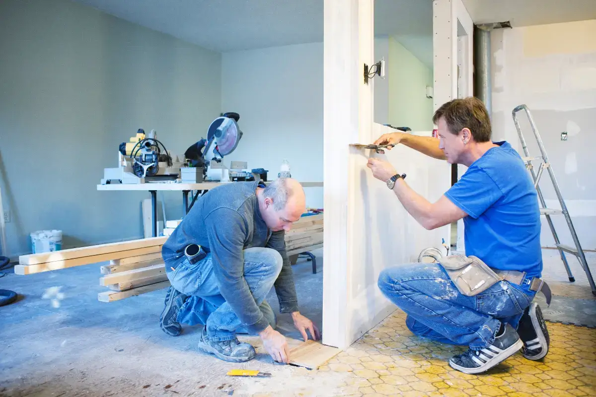 Imagem com dois profissionais executando a reforma em uma casa.