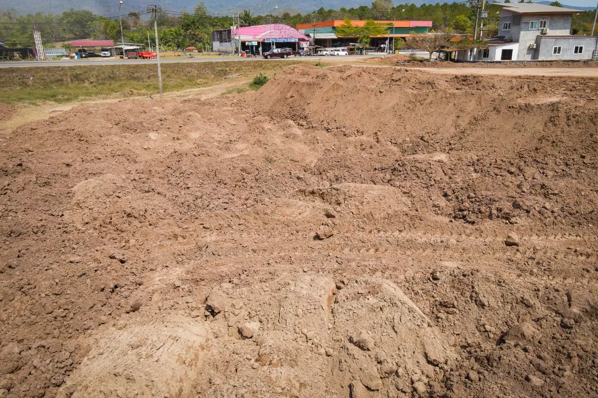 Como calcular os custos de drenagem e nivelamento do terreno? Imagem de moradores preocupados com irregularidades no solo. Foto: Reprodução / Canva Pro.