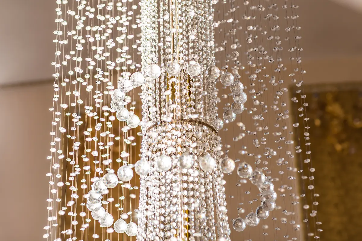 Estilo Clássico! Detalhe de um lustre de cristal que adiciona sofisticação ao ambiente clássico. Foto: Reprodução / Canva Pro.