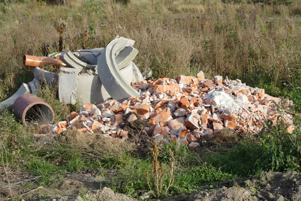 Entulho acumulado no terreno: descubra o perigo silencioso escondido no seu lote! Morador indignado encará pilha de entulho em lote baldios. Foto: Reprodução / Canva Pro.