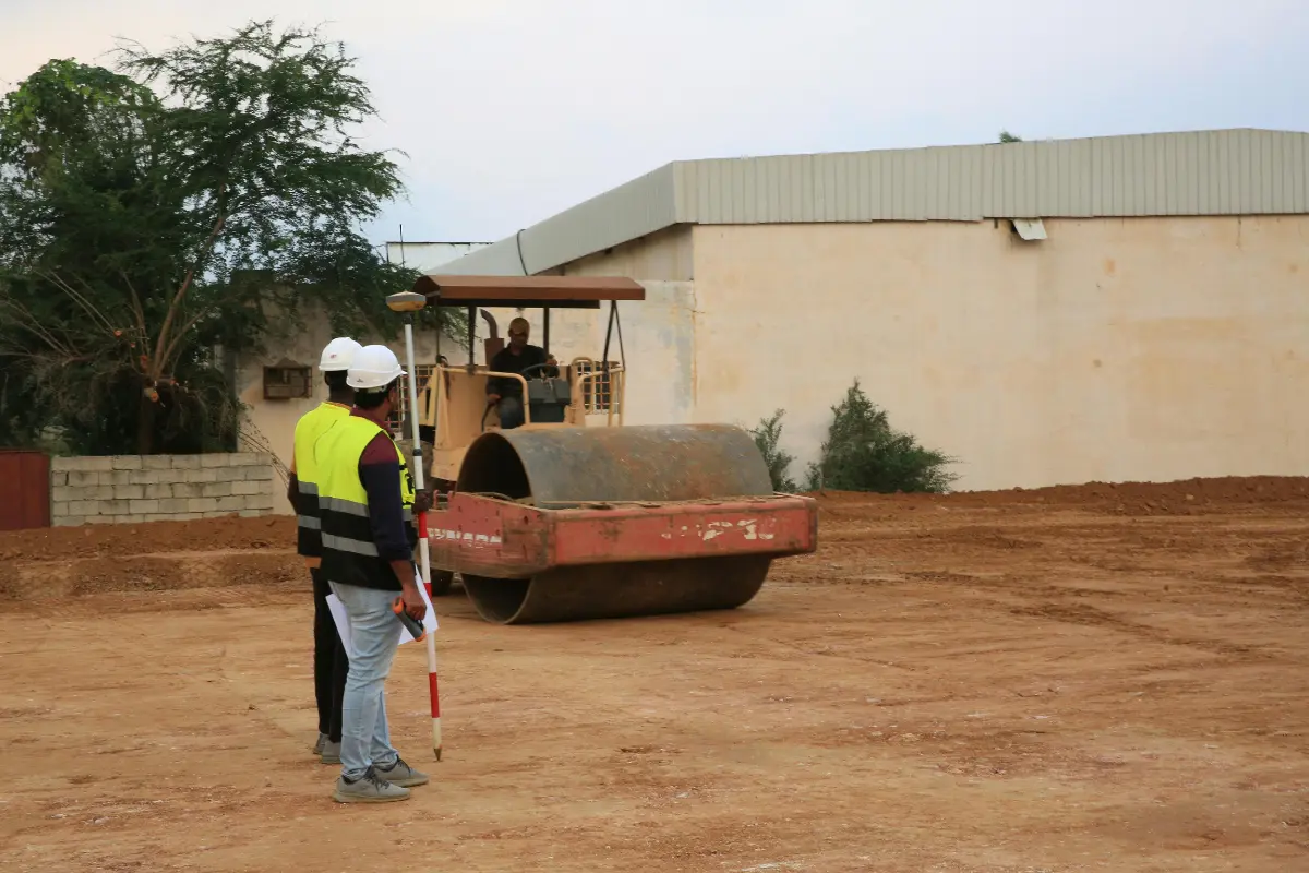 Terraplanagem de terreno: Operários trocando olhares de confiança enquanto trabalham. Foto: Reprodução / Canva Pro.